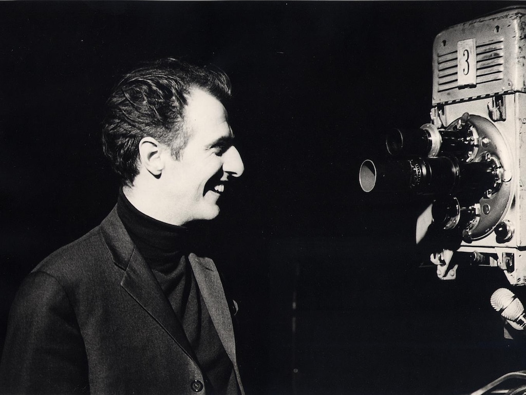Gilles Vigneault en 1966 regarde une caméra en souriant.